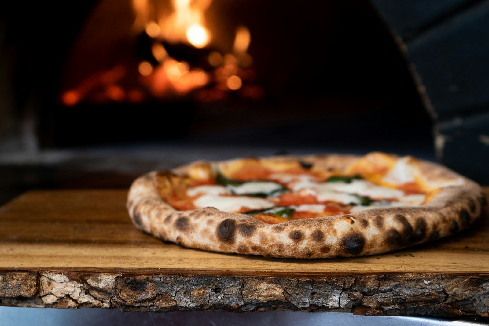 Pizza w stylu neapolitańskim na drewnianym stole